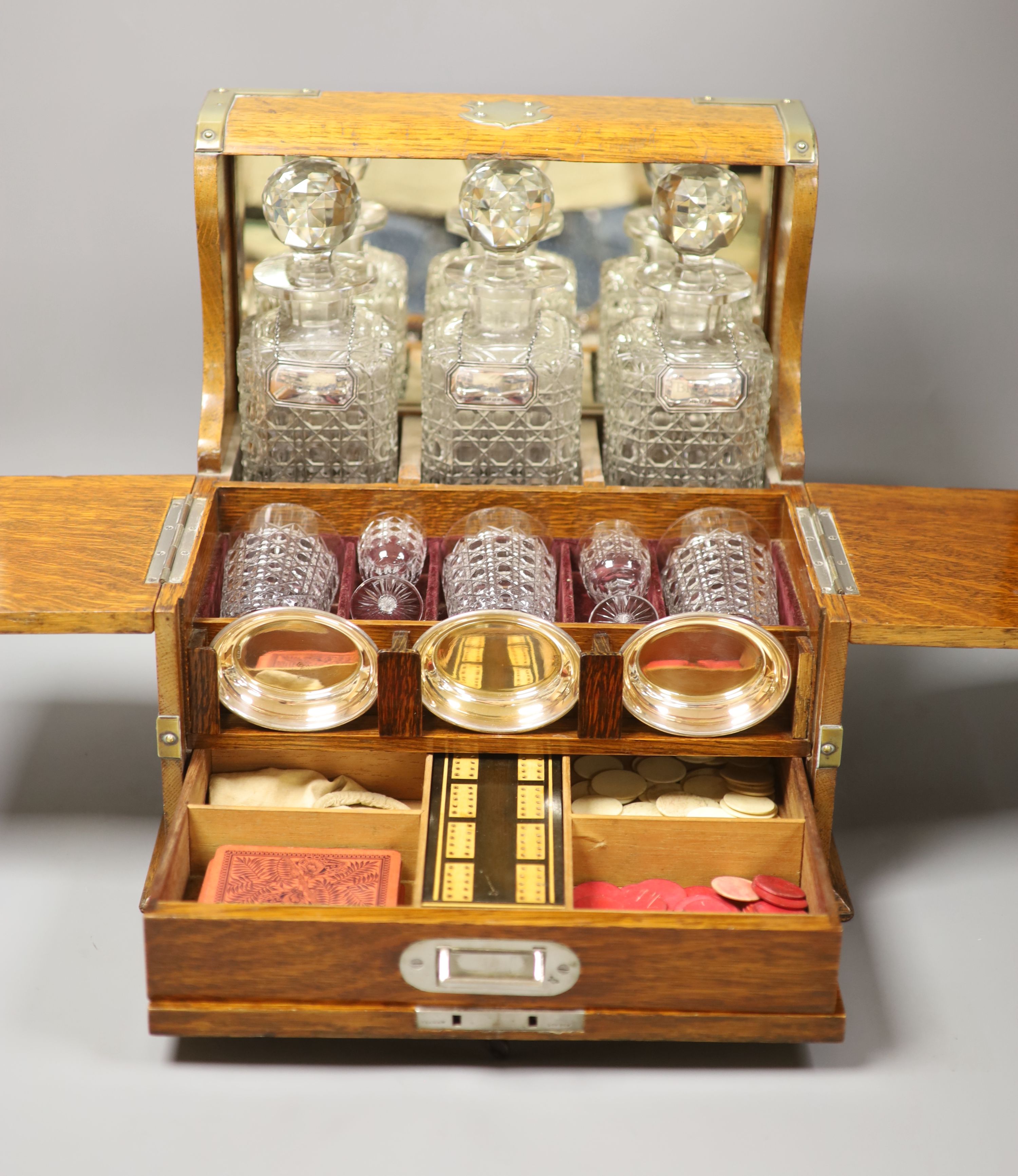 A good Victorian oak and brass mounted tantalus and combination games box, height 35.5cm width 36cm depth 30cm